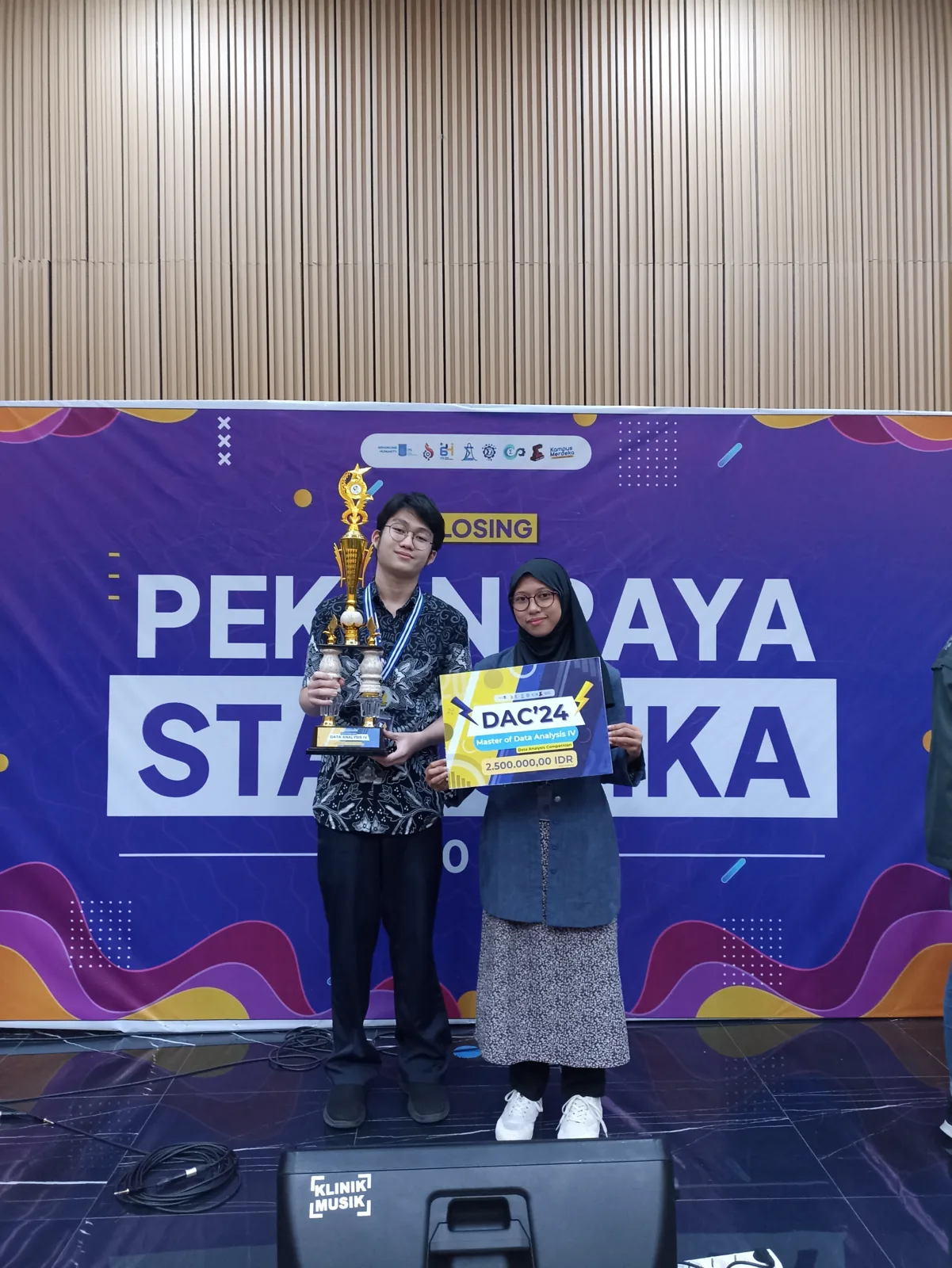 me and my teammate receiving the Data Analysis Competition trophy
